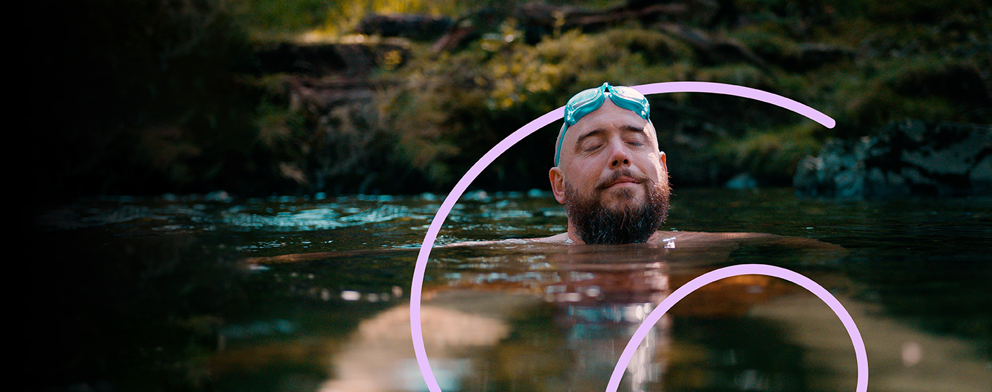 A person with a beard and goggles is in water. 